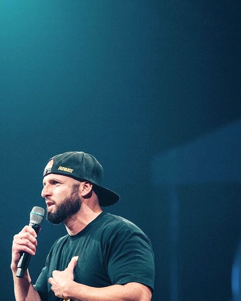 Andrew Boganwright on stage with a microphone